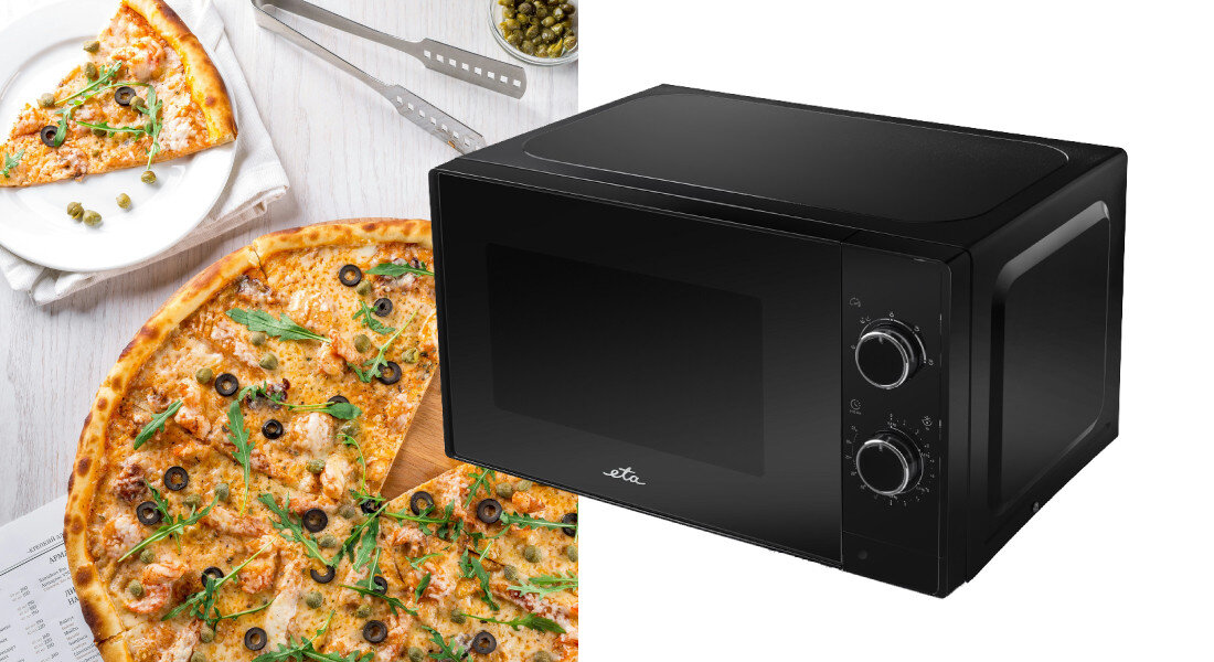 Czarna kuchenka mikrofalowa z dwoma pokrętłami i logo \'eta\' na drzwiczkach. Obok znajduje się pizza z oliwkami i rukolą na białym talerzu.