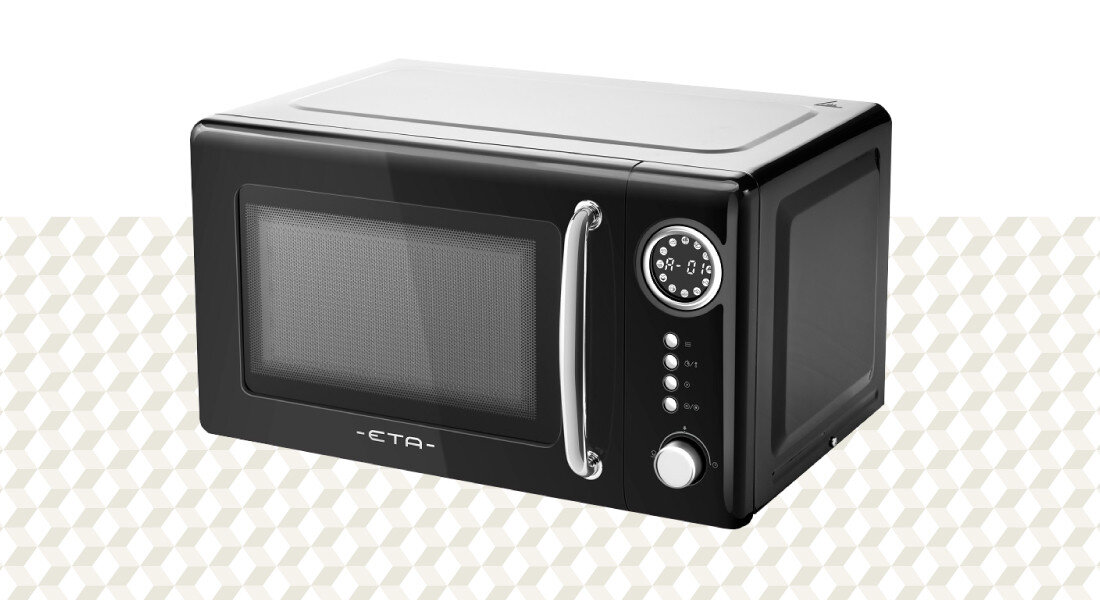 Kuchenka mikrofalowa ETA Storio ETA321090020 Zdjęcie przedstawia kuchenkę mikrofalową ETA w ujęciu produktowym na jasnym, wzorzystym tle. Wyraźnie widoczny jest czarny front, srebrny uchwyt oraz panel sterowania po prawej stronie moc 700 W równomierne podgrzewanie rozmrażanie gotowanie szybkie działanie