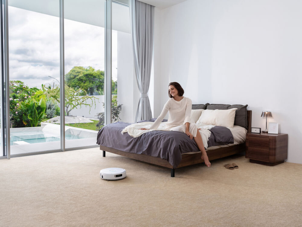 Robot sprzątający NARWAL Flow Station Kobieta wydaje instrukcje sprzątania głosem, a robot sprzątający opuszcza stację bazową i rozpoczyna pracę.