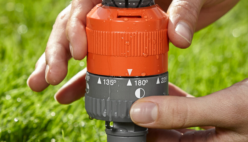 Zraszacz GARDENA Vario 1949-20 zbliżenie na pokrętło do regulacji osoba ustawia pozycję ustawienie sektorów zraszania w siedmiu pozycjach od 90° do 360° w krokach co 45° precyzyjnie dopasować strumień wody do kształtu ogrodu