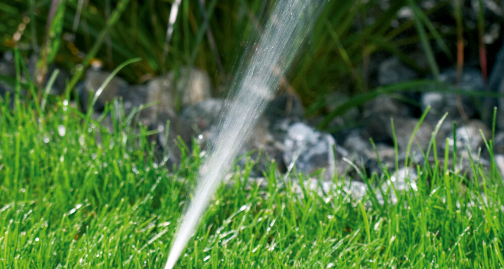Zraszacz GARDENA 2060-20 ogród krzewy kwiaty zbliżenie na strumień wody regulowane precyzyjne dysze rozprowadzają wodę równomiernie zasięg pracy od 3 do 18 metrów zapobiega przesuszeniu i nadmiernemu nawodnieniu gleby