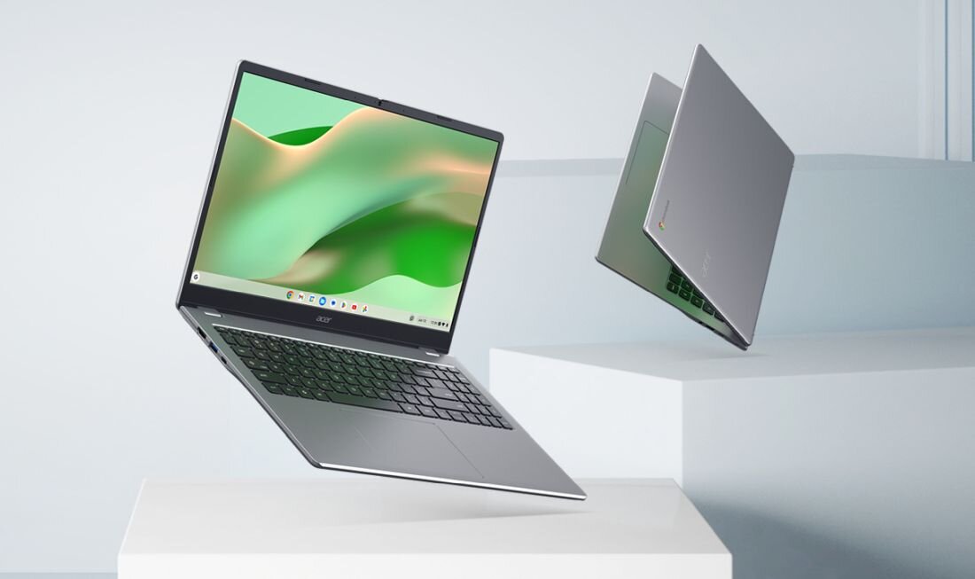 Dwa laptopy w kolorze srebrnym, jeden otwarty z widocznym ekranem i klawiaturą, drugi zamknięty. Na ekranie otwartego laptopa widoczny jest abstrakcyjny, zielono-żółty wzór.