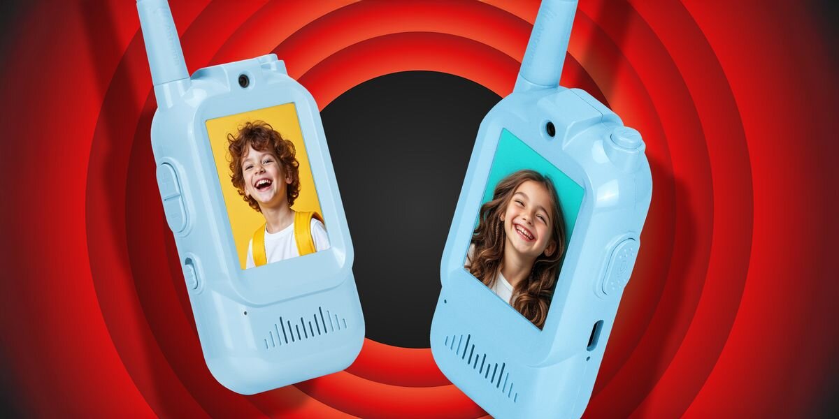 Krótkofalówka REDLEAF Walkie-talkie WT2 Niebieski, Niebieski (2 szt.), Zasięg, łączność, bezpieczeństwo, teren, Dwie dziecięce krótkofalówki – różowa i niebieska – leżą na drewnianym stole; niebieska jest podłączona do ładowania kablem USB, w tle widać zabawki i jasne wnętrze pokoju dziecięcego