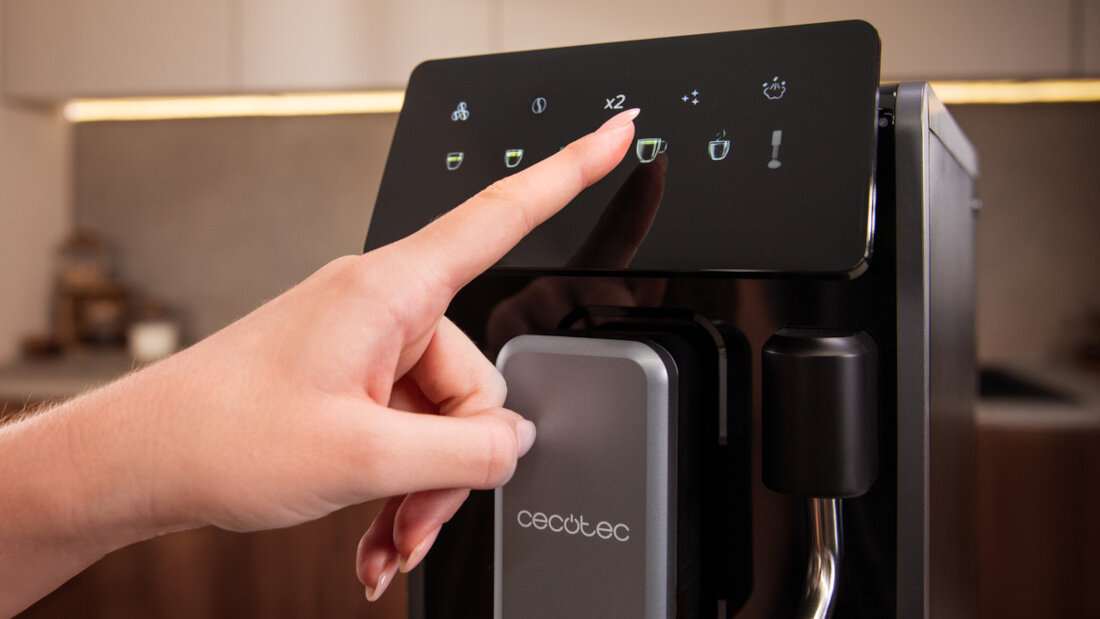 Osoba dotyka panelu sterowania ekspresu do kawy z widocznymi ikonami i napisem \'cecotec\'.