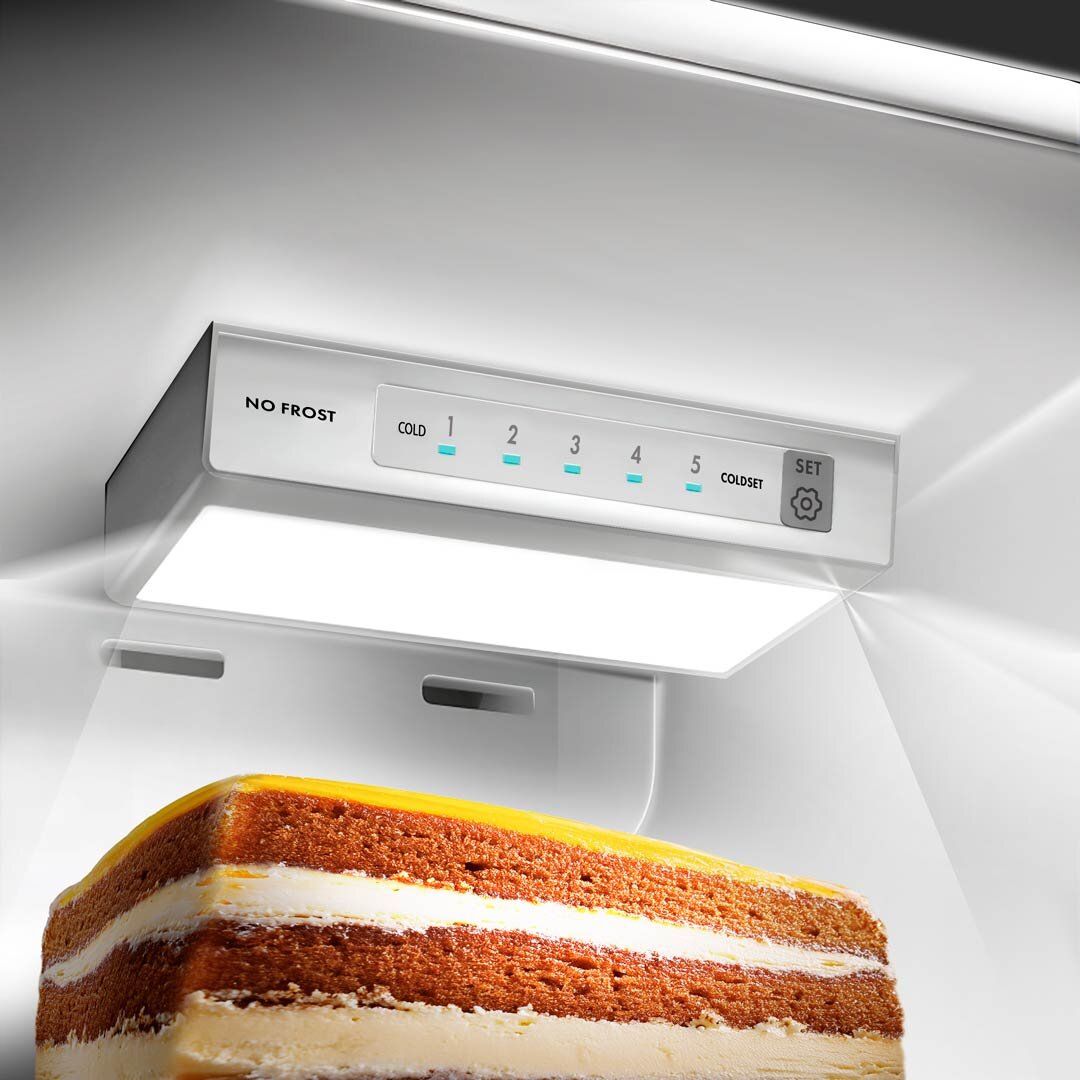 Lodówka LIN LI-BCD-190 No Frost 149cm Biała Zdjęcie przedstawia wnętrze lodówki z panelem sterowania NO FROST umieszczonym pod górną półką, z wyraźnie oznaczonymi poziomami chłodzenia. Na dolnym planie widoczny jest kawałek ciasta, co podkreśla funkcjonalne oświetlenie i równomierne chłodzenie przechowywanej żywności oświetlenie panel elektroniczny świeżość bezpieczeństwo pełna widoczność