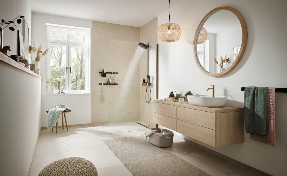 BATERIA UMYWALKOWA HANSGROHE TECTURIS Bateria umywalkowa zamontowana przy ceramicznej umywalce z płynącym strumieniem wody. Obok znajdują się mydelniczka, kubek na szczoteczki i ręcznik w dopasowanej kolorystyce