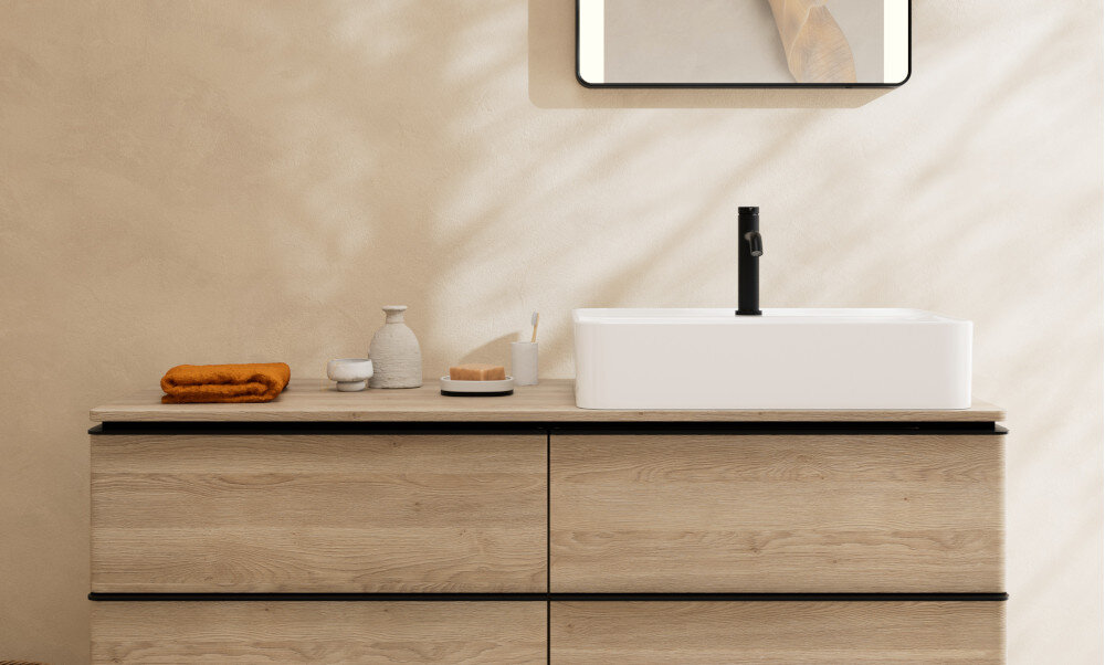 BATERIA UMYWALKOWA HANSGROHE TECTURIS Bateria umywalkowa zamontowana przy ceramicznej umywalce z płynącym strumieniem wody. Obok znajdują się mydelniczka, kubek na szczoteczki i ręcznik w dopasowanej kolorystyce