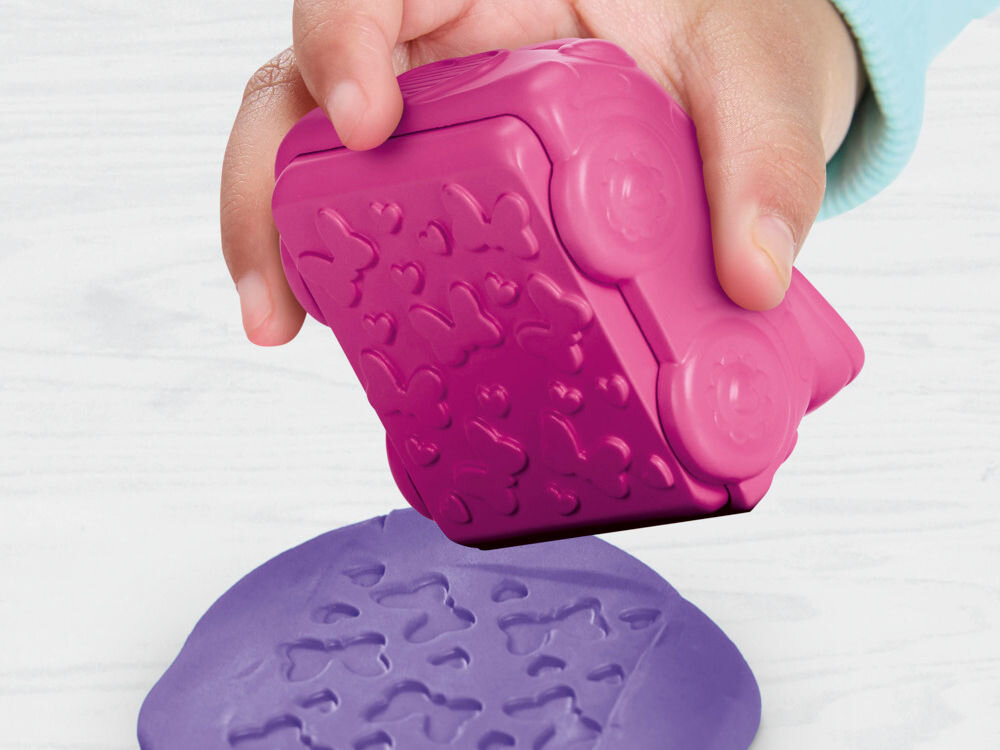 Ciastolina PLAY-DOH Disney Junior zestaw pieczątek G31105L0 Dłonie dziecka trzymające otwartą żółtą foremkę Play-Doh w kształcie koła zębatego z odciśniętym motywem Myszki Miki. Wewnątrz znajduje się zielona ciastolina, a obok leżą gotowe niebieskie i żółte krążki.