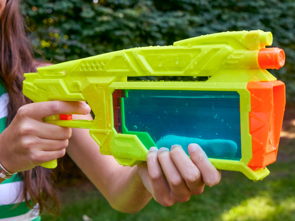 Wyrzutnia NERF Super Soaker Dunk-Fill+ G21465L0 Zbliżenie na napełnioną wodą wyrzutnię Nerf Super Soaker trzymaną przez osobę w pasiastej koszulce.