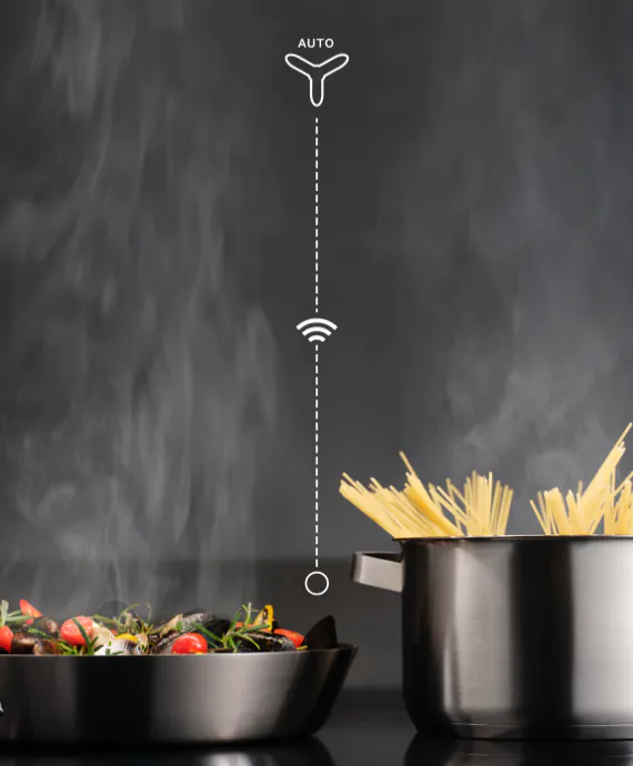 Na obrazie widoczne są dwa garnki na płycie kuchennej, z których jeden zawiera spaghetti, a drugi potrawę z warzywami. Nad garnkami znajduje się symbol z napisem \'AUTO\' oraz ikona sygnału bezprzewodowego.