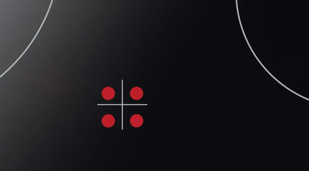 Czarna powierzchnia z dwoma białymi okręgami i czterema czerwonymi kropkami ułożonymi w kwadrat z liniami krzyżującymi się pośrodku.