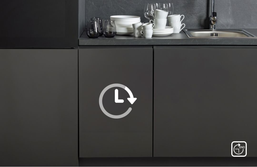 ZMYWARKA HISENSE HV543D10 Ciemna zabudowa kuchenna z blatami w grafitowym kolorze, na blacie stoi stos brudnych naczyń i szklanek, a na froncie szafki nadrukowano symbol zegara z okrężną strzałką, sugerujący opóźniony start zmywarki