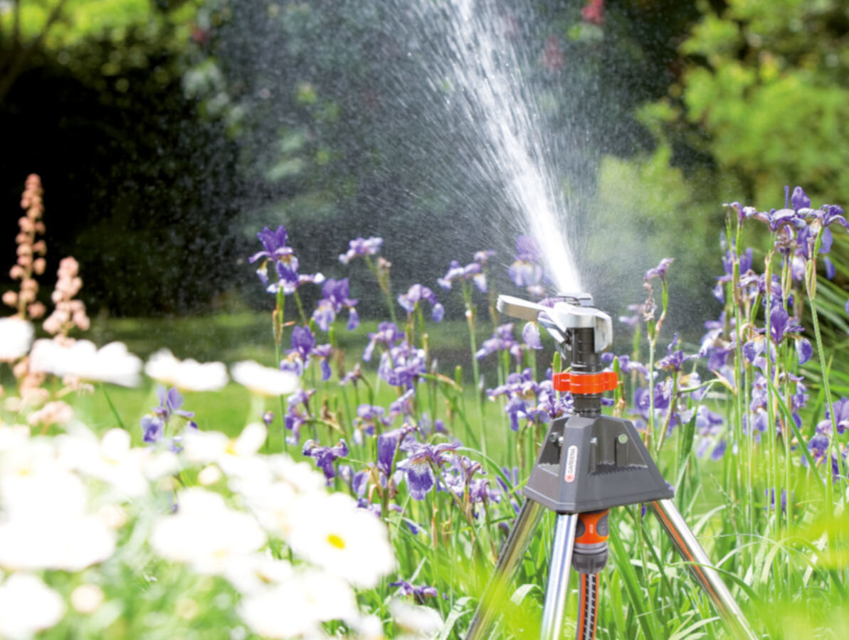 Zraszacz GARDENA Premium na statywie 8138-20, woda, zraszanie, podlewanie, ogród, w tle ogród zraszacz podlewa kwiaty w ogrodzie