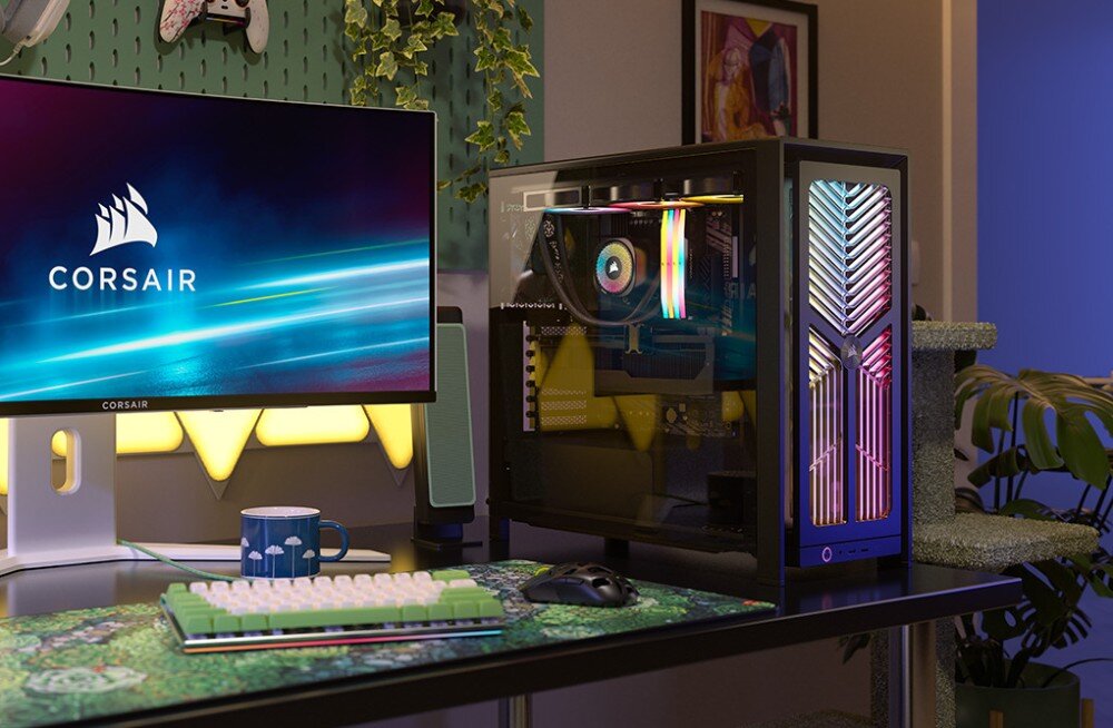 Obudowa CORSAIR Frame 4000X RS Czarna obudowa komputerowa z kolorowym podświetleniem frontu stoi na biurku w pokoju obok monitora, klawiatury i myszki