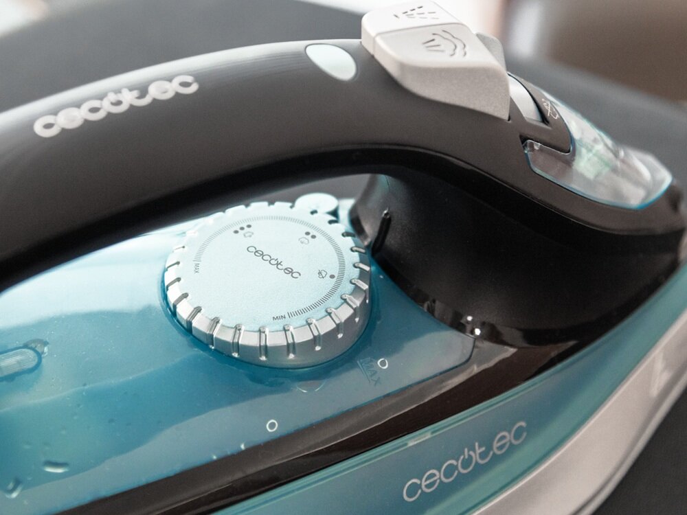 Zdjęcie przedstawia żelazko z widocznym logo \'cecotec\' na uchwycie i pokrętle. Żelazko ma czarny uchwyt i niebieski zbiornik na wodę.