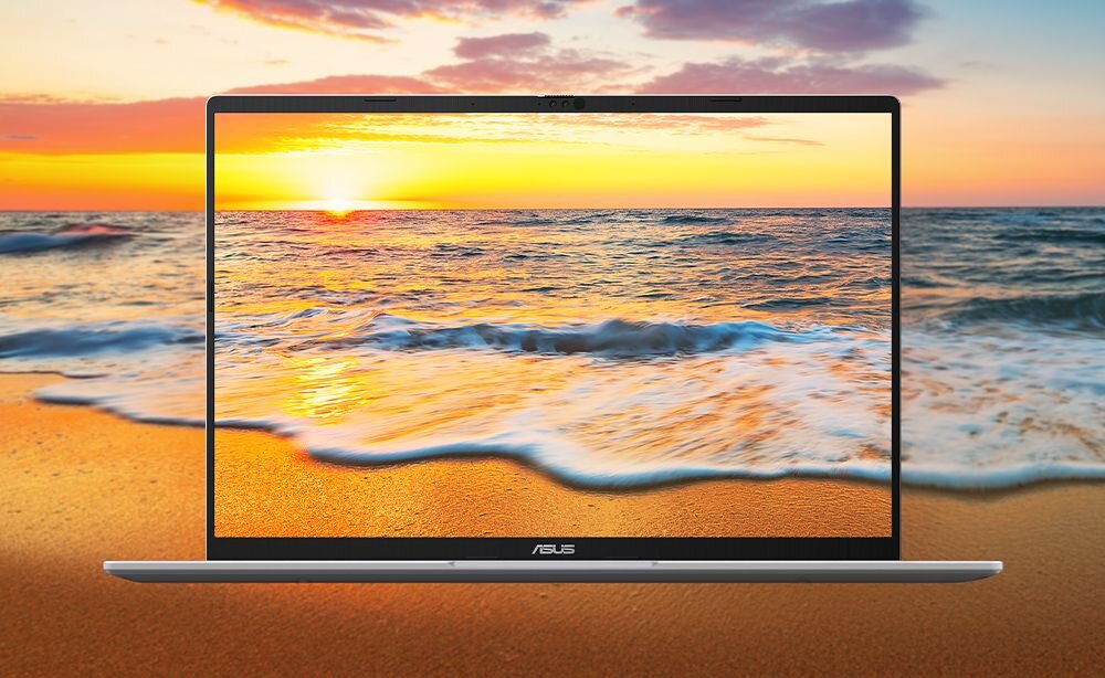 Laptop z wyświetlaczem pokazującym zachód słońca nad morzem. Na dolnej ramce ekranu widoczne jest logo ASUS.