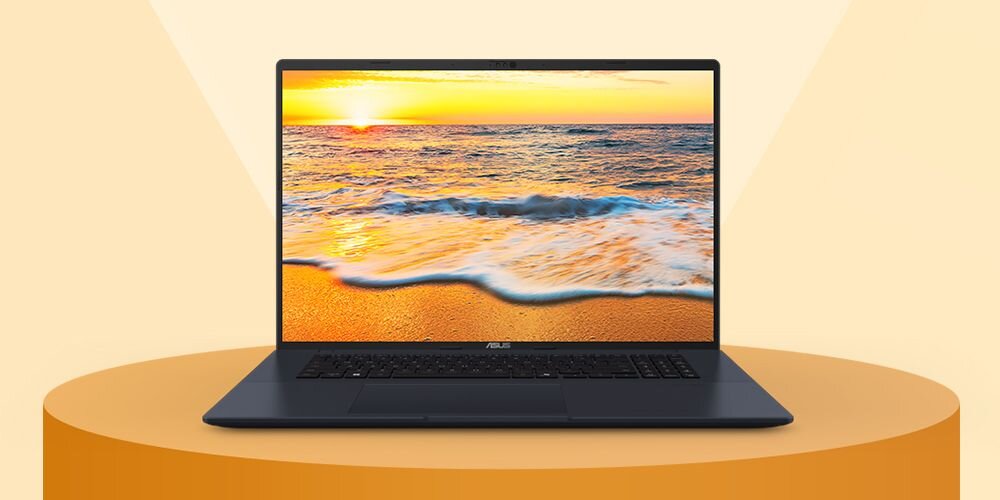 Laptop z wyświetlaczem pokazującym plażę o zachodzie słońca. Na obudowie widoczne jest logo ASUS.