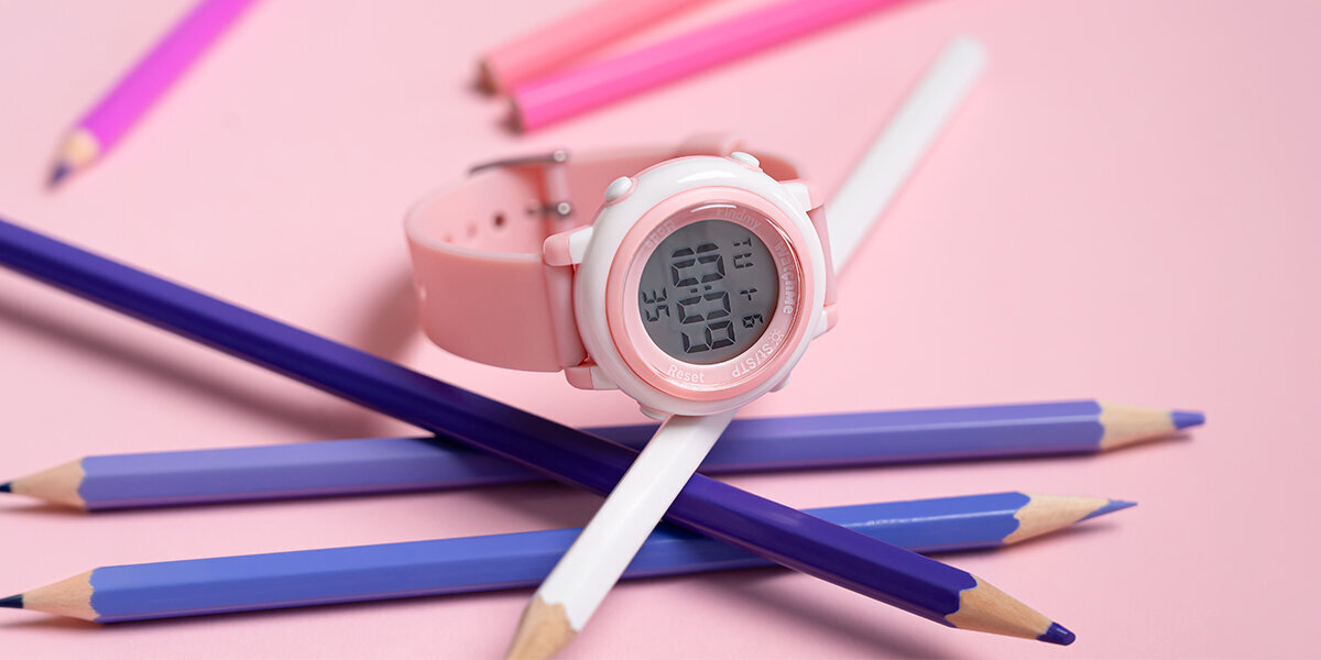 Smartwatch SPONGE WatchMe Kids obok cieńkich kredek.