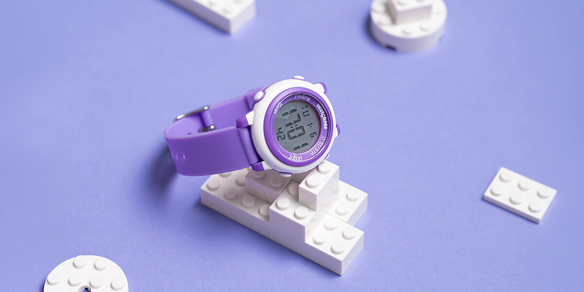 Smartwatch SPONGE WatchMe Kids leżący na zabawkowych klockach.
