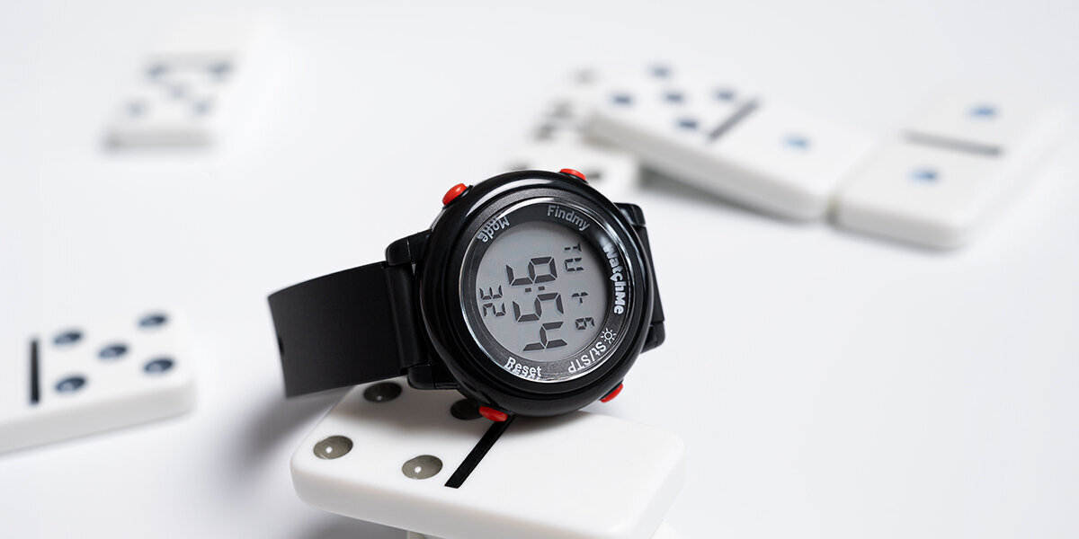 Smartwatch SPONGE WatchMe Kids obok rozrzuconego domino.