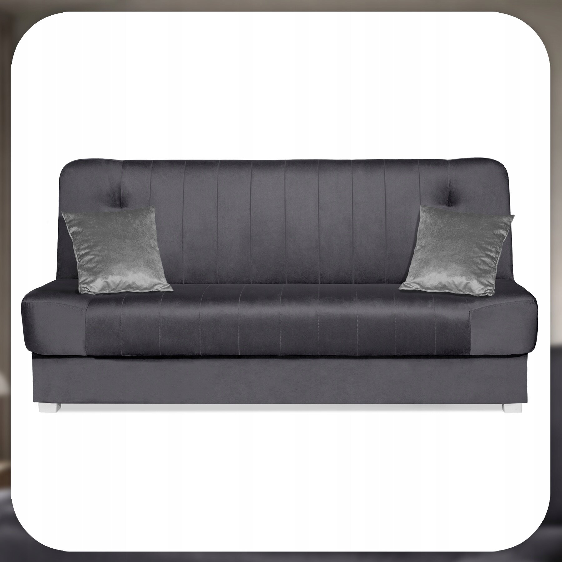 Szara welurowa sofa z funkcją spania, z dwoma poduszkami dekoracyjnymi. Sofa ma prosty, nowoczesny design z pionowymi przeszyciami na oparciu.