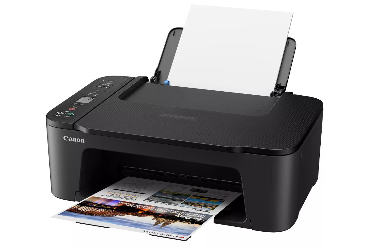 Czarne urządzenie wielofunkcyjne Canon Pixma z otwartą pokrywą i widocznym papierem w podajniku. Na obudowie widoczne jest logo Canon, a z przodu urządzenia wychodzi wydrukowana kolorowa strona.