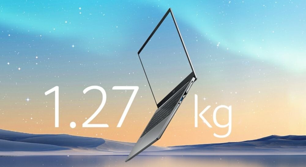 Obraz przedstawia laptopa na tle nieba o zmierzchu. Na obrazie widoczny jest tekst: \'1.27 kg\'.