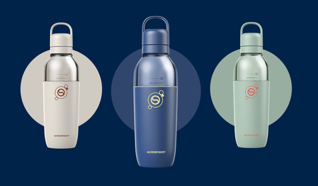 Trzy butelki termiczne w kolorach białym, granatowym i miętowym, każda z logo sodastream na środku. Butelki mają zakrętki z uchwytami i są ustawione na ciemnoniebieskim tle.