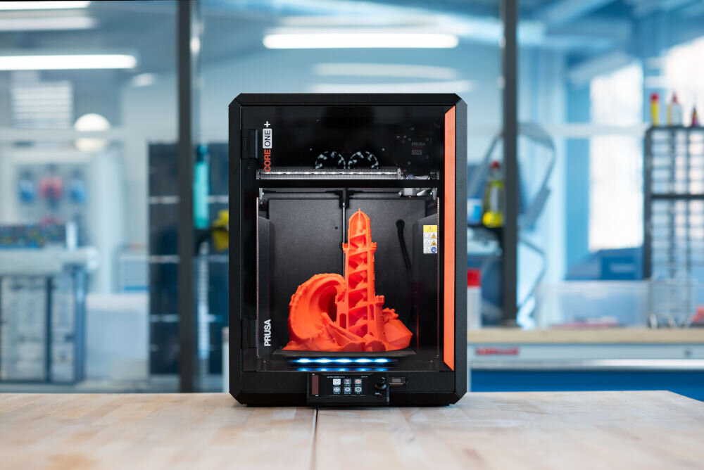 Drukarka 3D PRUSA Core One+ Wi-Fi, LAN (Zamontowana) Widok na drukarkę z modelem 3D w biurze temperatura 55°C, kontrola termiczna, powtarzalność