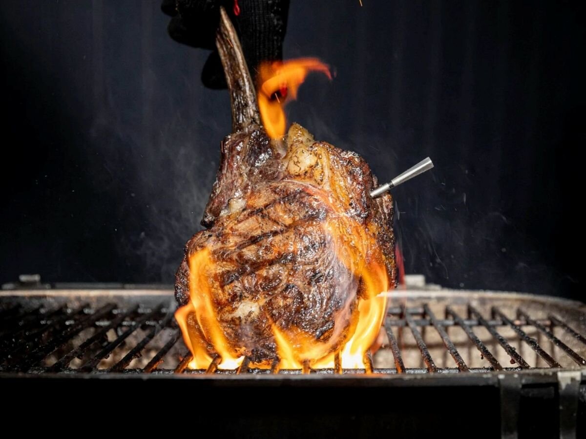 Termometr MEATER Pro, dokładność, pomiar, mięso, ryba, Stek tomahawk na grillu w ogniu z sondą MEATER.