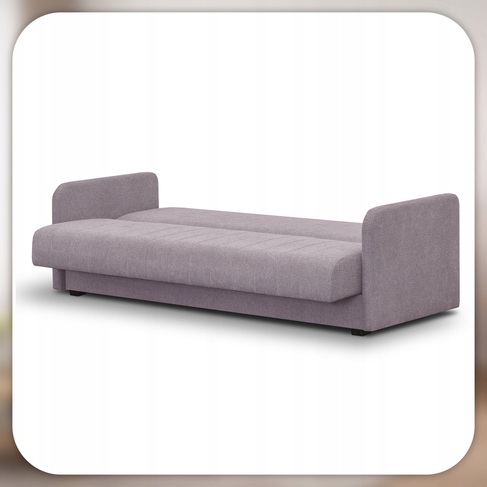 Na obrazie widoczna jest rozłożona sofa w kolorze beżowym z funkcją spania, posiadająca proste podłokietniki po obu stronach. Sofa stoi na tle białej ściany.