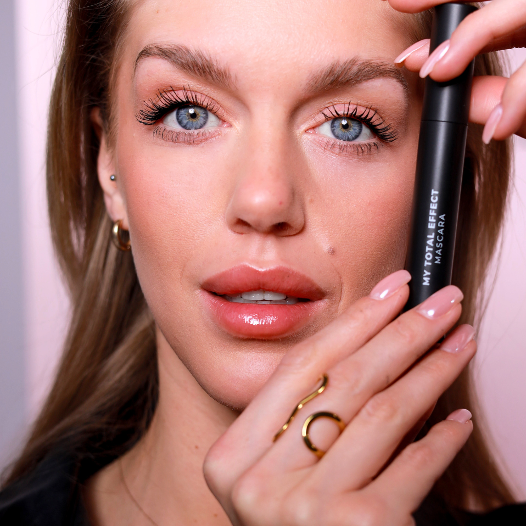 Osoba trzyma czarny tusz do rzęs z napisem \'MY TOTAL EFFECT MASCARA\'.