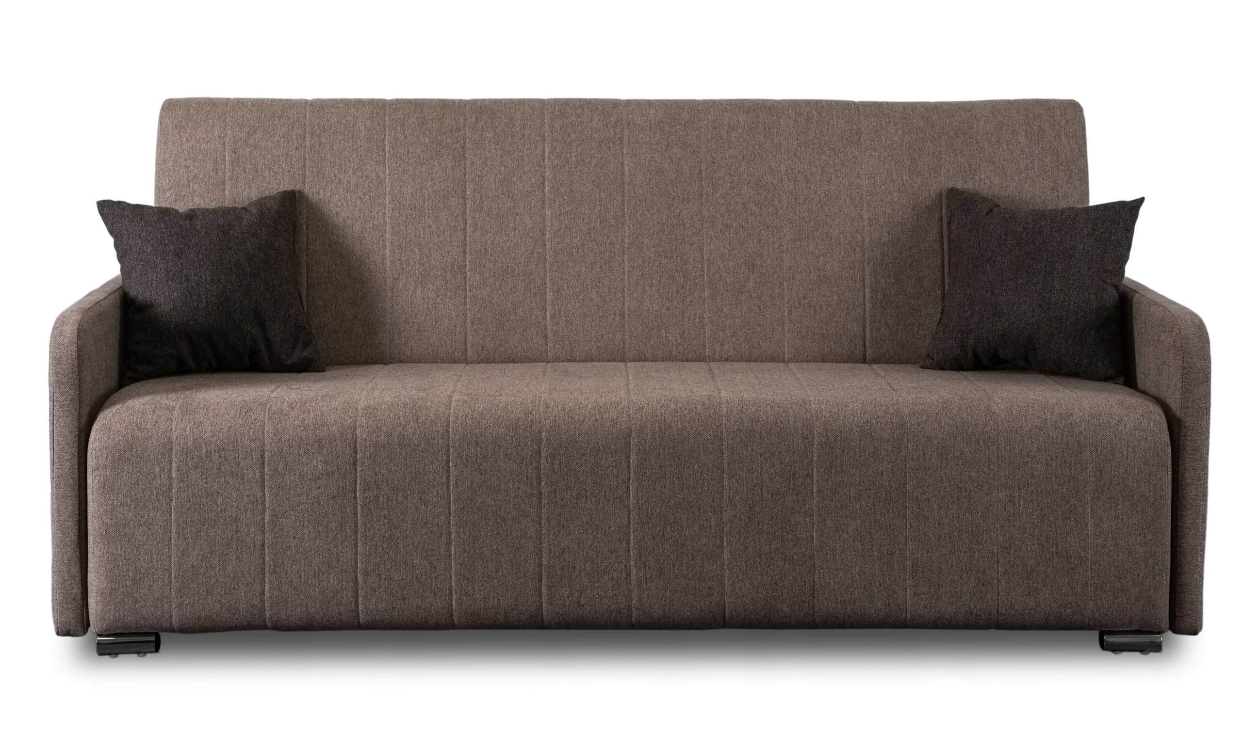 Beżowa sofa z funkcją spania, z dwoma ciemnymi poduszkami po bokach. Sofa ma prosty, nowoczesny design z widocznymi pionowymi przeszyciami na oparciu i siedzisku.