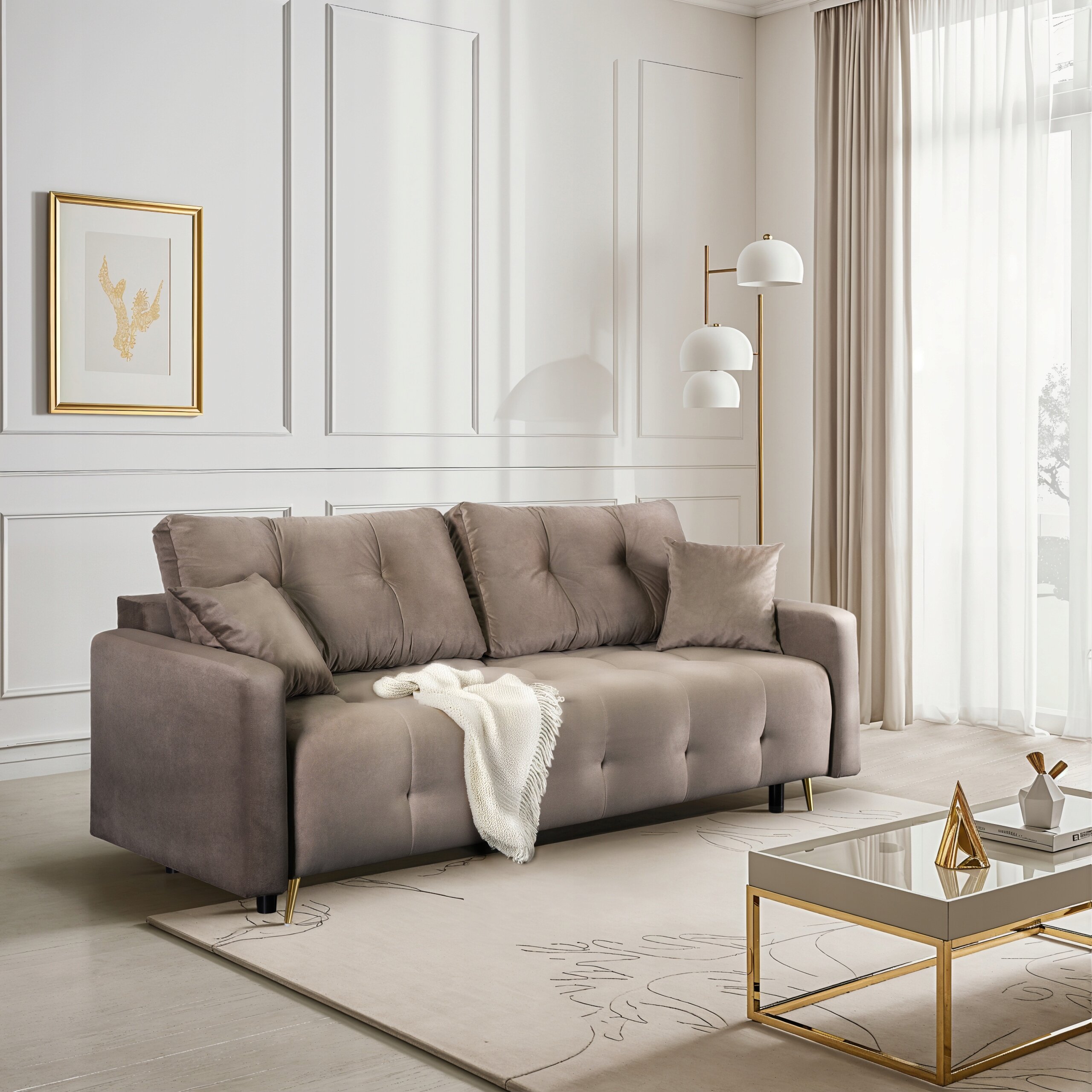 Beżowa sofa rozkładana z funkcją spania stoi w eleganckim, jasnym salonie. Obok sofy znajduje się nowoczesna lampa stojąca, a na ścianie wisi obraz w złotej ramie.