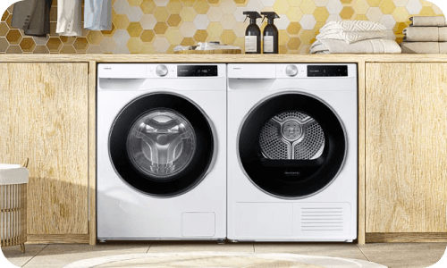 2 kv suszarka top img Pralka i suszarka umieszczone obok siebie w nowoczesnej łazience z drewnianymi akcentami.