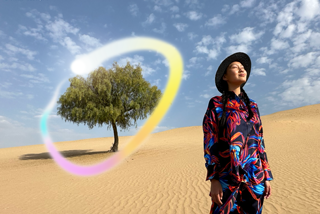 Widoczny od przodu iPad Pro, na ekranie wiele otwartych aplikacji na tle o gradiencie od ciemnoniebieskiego do zielonego. Dłoń trzyma rysik Apple Pencil Pro i zakreśla szkic, używając funkcji różdżki graficznej Apple Intelligence