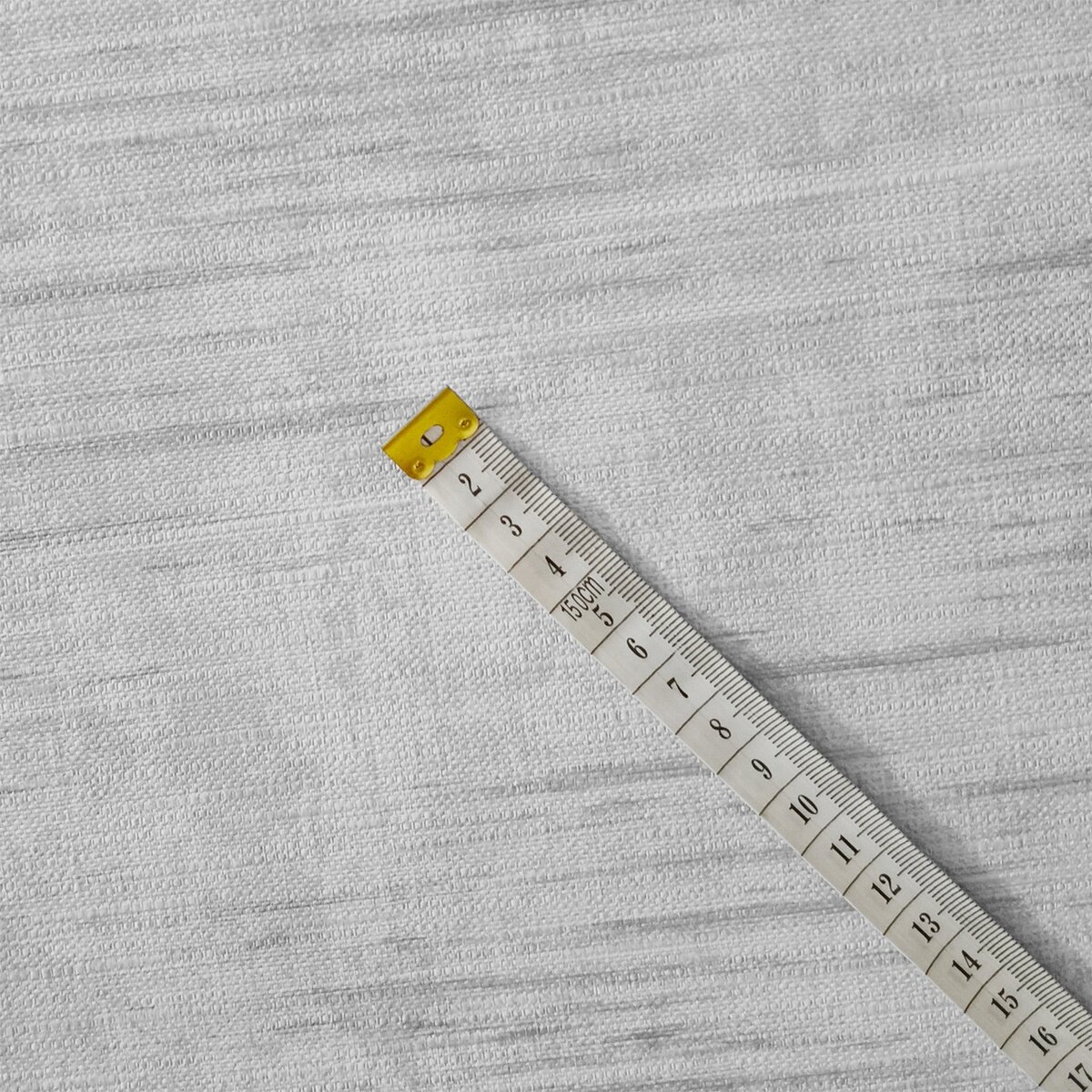 Na obrazie widoczna jest biała cerata o teksturowanej powierzchni, na której leży miarka z podziałką centymetrową od 2 do 16 cm.