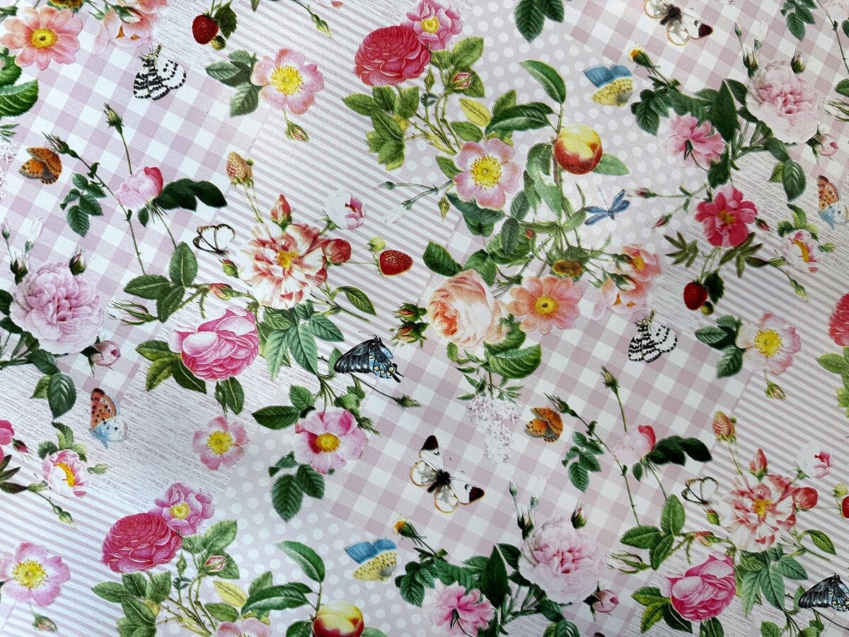 Obraz przedstawia ceratę z wzorem kwiatowym, na której widoczne są różnokolorowe kwiaty i motyle na tle w kratkę i kropki.