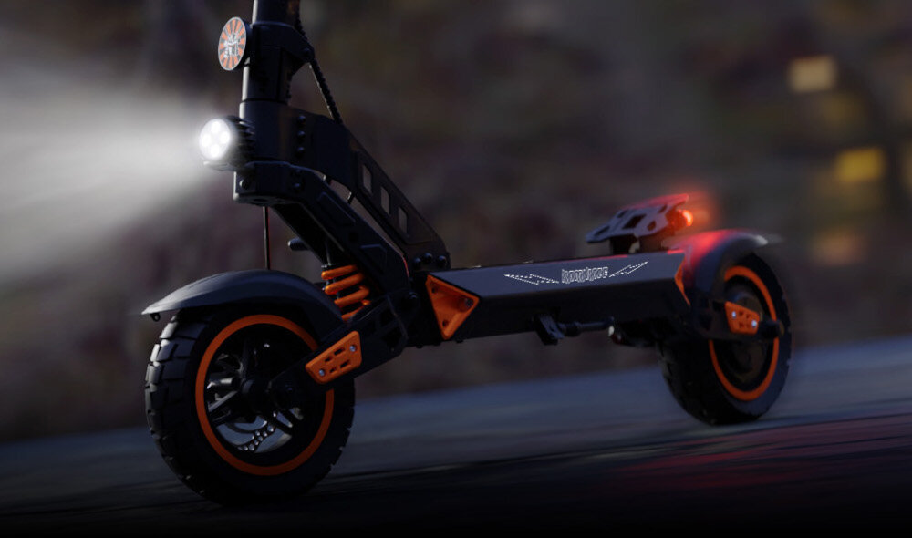 Hulajnoga elektryczna KAMIKAZE K1 Plus Plus 80km 1000W 10 cali Czarny droga ulica ciemność zbliżenie na podest przednia lampa się świeci przednie i tylne światło LED praktyczne kierunkowskazy wbudowane w podest jasna lampa z przodu efektowne podświetlenie platformy bezpieczeństwo łatwe i czytelne sygnalizowanie zmiany kierunku