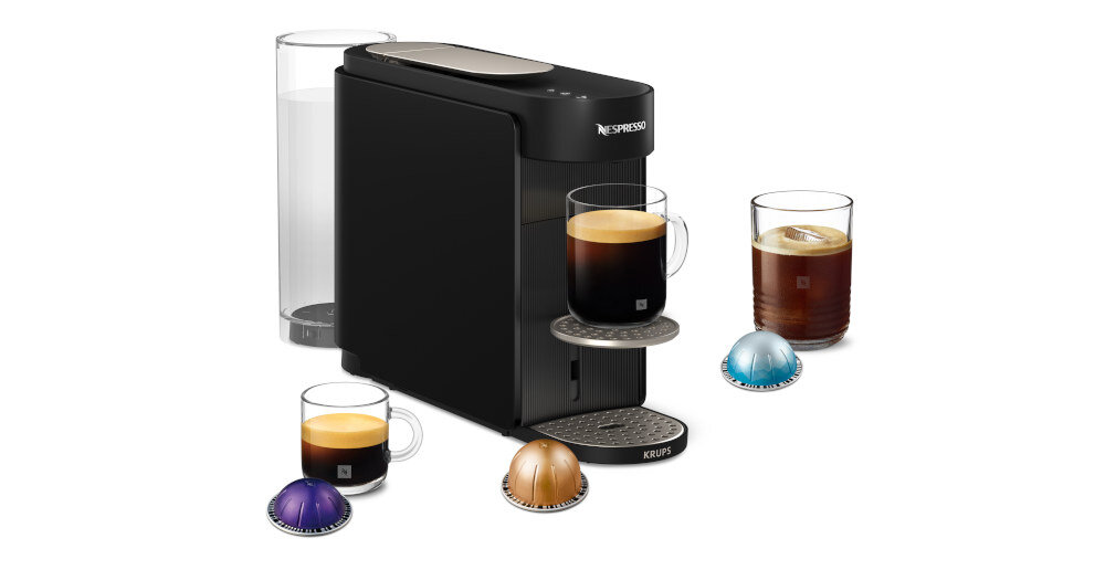 Czarny ekspres do kawy z logo Nespresso i Krups, obok którego znajdują się filiżanki z kawą oraz kolorowe kapsułki. Ekspres ma cylindryczny pojemnik na wodę z tyłu.