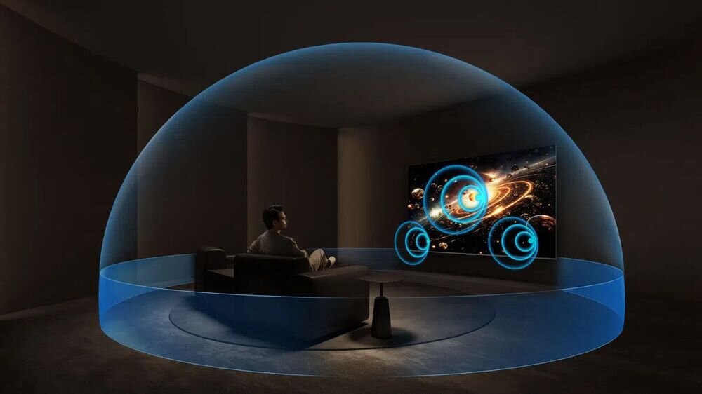 Telewizor IFFALCON 55U85 audio 2.1 50W mocny dźwięk bas kino domowe, telewizor zawieszony na ścianie, osoba siedząca na kanapie otoczona dźwiękiem