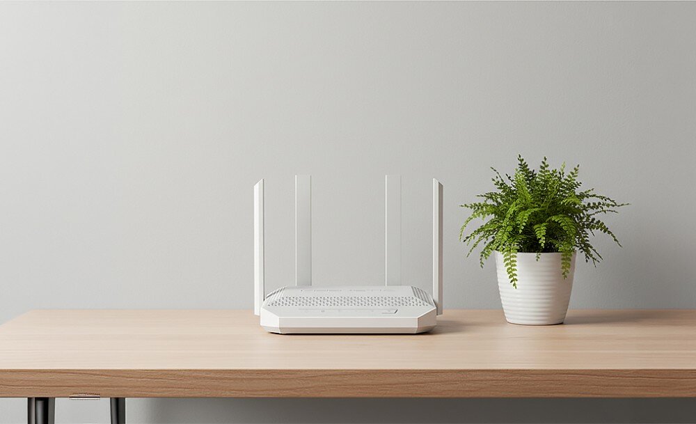 Router KEENETIC Hopper 4G+ Router z czterema antenami ustawiony centralnie na drewnianej powierzchni obok zielonej rośliny w białej doniczce na tle gładkiej, jasnej ściany