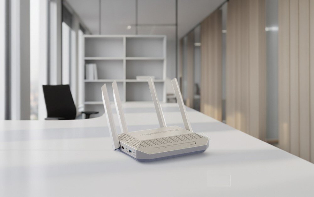 Router KEENETIC Titan 3 białe urządzenie sieciowe z czterema antenami spoczywa na białym blacie w jasnym biurze z widocznymi w tle regałami i oknami