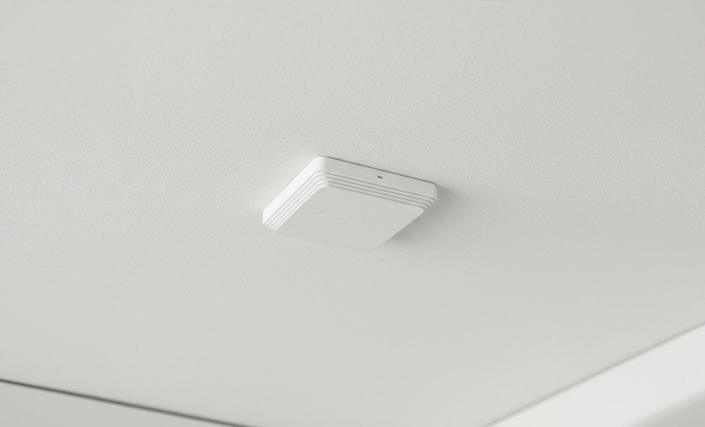 Punkt dostępu KEENETIC Orbiter Pro AC1300 Widok od dołu na białe kwadratowe urządzenie zamontowane na gładkiej powierzchni białego sufitu