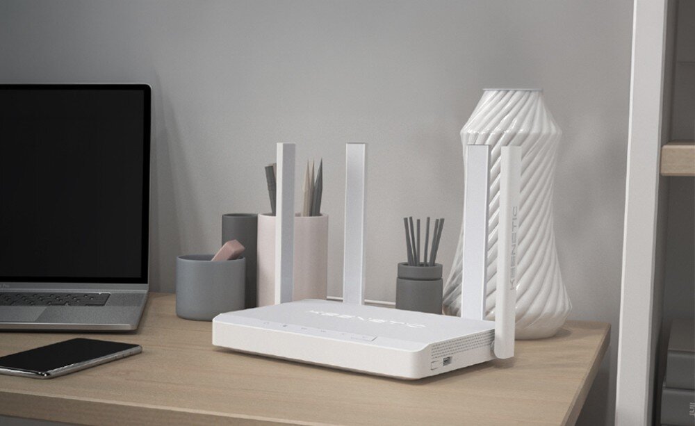 Router KEENETIC Hopper DSL Urządzenie sieciowe z dwiema zamontowanymi pionowo antenami leży na białym blacie, a obok znajdują się dwie odłączone anteny i zwinięty biały przewód