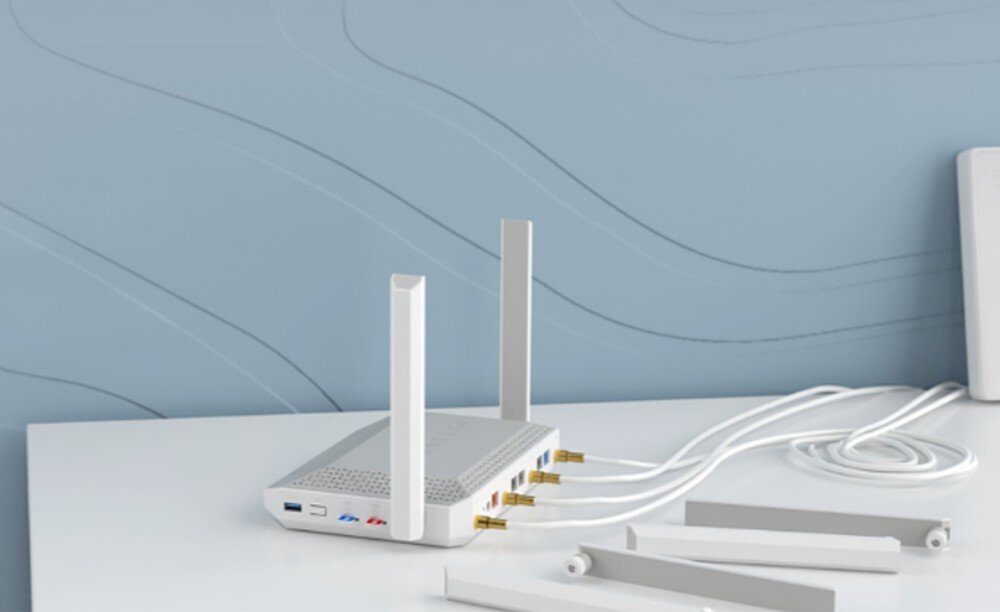 Router KEENETIC Hero 5G Biały router na białym blacie z dwiema zamontowanymi antenami oraz czterema leżącymi obok i wpiętymi kablami