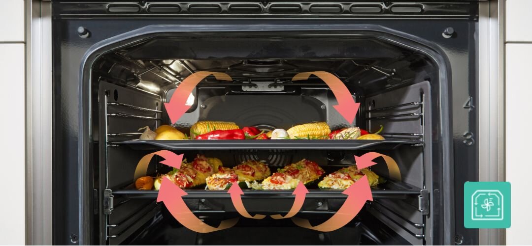 KUCHNIA GORENJE MEKS5141BM Wnętrze piekarnika z dwiema blachami pełnymi warzyw i przekąsek, wokół których umieszczono pomarańczowe strzałki symbolizujące równomierną cyrkulację gorącego powietrza na kilku poziomach