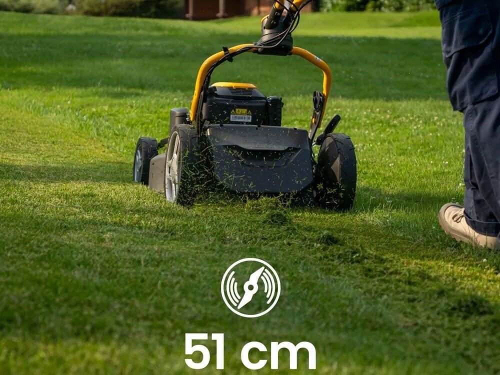 Osoba obsługuje kosiarkę spalinową na trawniku, a na obrazie widoczny jest napis \'51 cm\'.