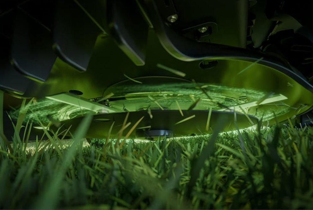 Robot koszący STIGA A 15V Bez przewodu ograniczającego Bluetooth 1500 m2, ostrza, regulacja, mulczowanie, koszenie, Zbliżenie od dołu na obracającą się tarczę z ostrzami tnącymi trawy pod robotem koszącym