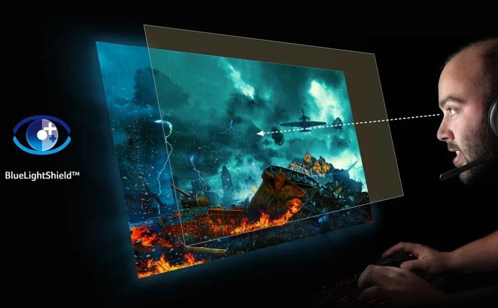 Osoba patrzy na monitor, na którym wyświetlana jest dynamiczna scena z gry z elementami ognia i burzy. Obok widoczne jest logo \'BlueLightShield™\'.